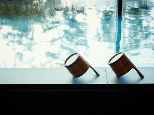 two wooden barrels sitting next to a swimming pool at Shima Kanko Hotel The Bay Suites in Shima