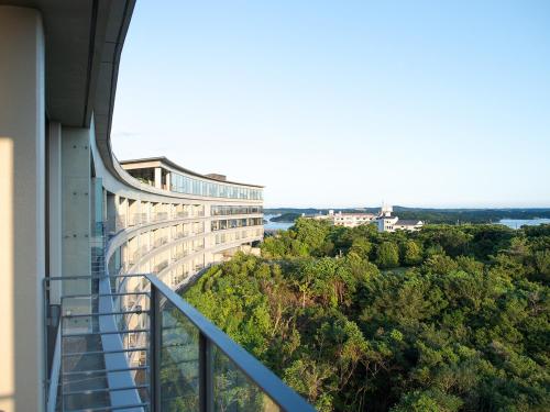 a balcony of a building with a view of trees at Shima Kanko Hotel The Bay Suites in Shima