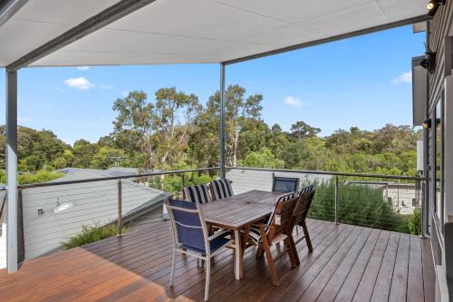 a deck with a wooden table and chairs at Surfs Up in Dunsborough