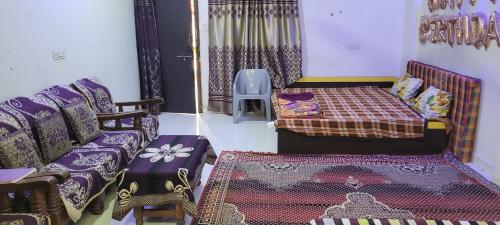 sala de estar con cama y sofá en chirayu home stay, en Ujjain
