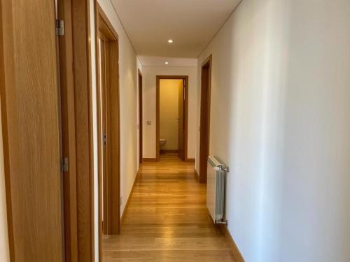 un corridoio con pareti bianche e pavimenti in legno di Ramona ad Aveiro