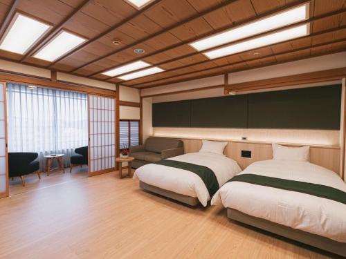 1 dormitorio grande con 2 camas y sofá en Hotel Kasuien, en Ureshino