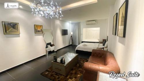 een kamer met een bed, een bank en een kroonluchter bij A In Hotel Glamour in Ho Chi Minh-stad