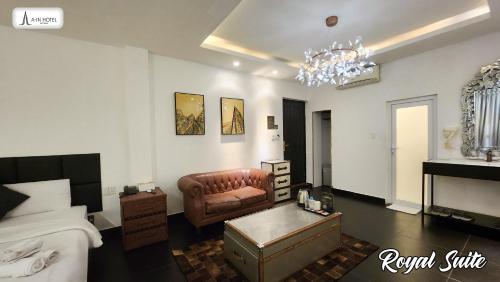 een slaapkamer met een bank, een bed en een kroonluchter bij A In Hotel Glamour in Ho Chi Minh-stad