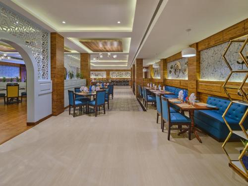 uma sala de jantar com mesas e cadeiras azuis em Fortune Park, Katra - Member ITC's Hotel Group em Katra