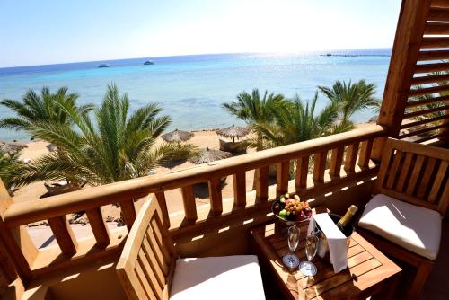 uma varanda com uma mesa e vista para a praia em The Breakers Diving and Surfing Lodge Soma Bay em Hurghada