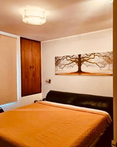 una camera da letto con un letto e un dipinto sul muro di Garencia a Montevideo