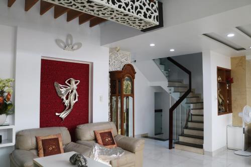 a living room with a couch and a staircase at Adventure Hotel in Ho Chi Minh City