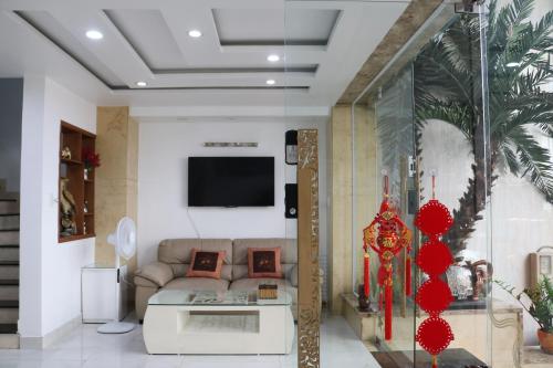 a living room with a couch and a tv at Adventure Hotel in Ho Chi Minh City