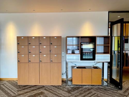 a room with lockers and a computer on a wall at Shima Kanko Hotel The Bay Suites in Shima