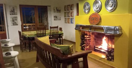 a dining room with a fireplace and a dining table at Koedoeskloof Guesthouse in Ladismith