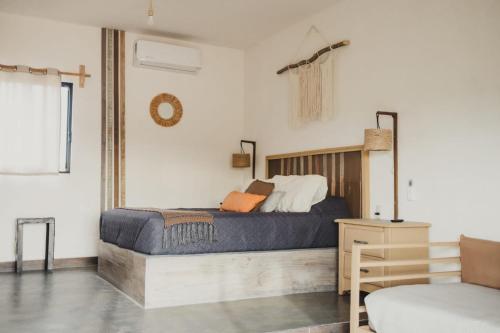 a bedroom with a bed with a wooden headboard at Tres Velas Surf in Celestino Gasca