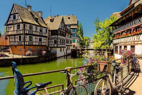 a bike parked next to a river with buildings at studio hyper centre ville et gare in Strasbourg