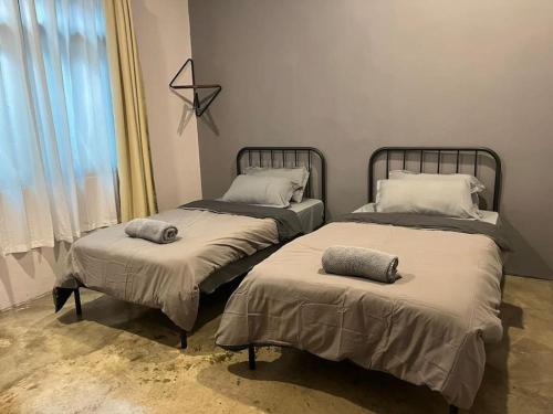 two beds sitting next to each other in a room at JW Homestay (ShopHouse Lv2) in Kudat
