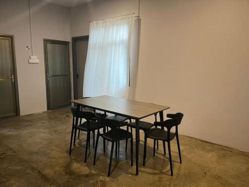 a wooden table and chairs in an empty room at JW Homestay (ShopHouse Lv2) in Kudat