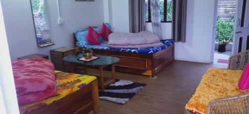 ein Wohnzimmer mit einem Sofa mit Kissen darauf in der Unterkunft Shriya Homestay in Kurseong