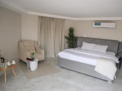 a bedroom with a large bed and a chair at Safari Desert Camp in Shāhiq
