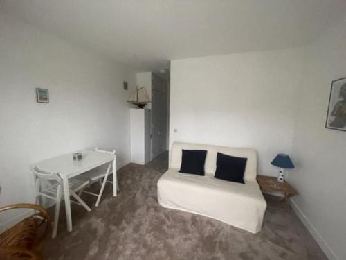 Cette chambre blanche dispose d'un canapé et d'une table. dans l'établissement Studio hypercentre Villers-sur-Mer, à Villers-sur-Mer