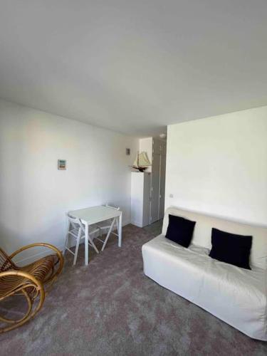une chambre blanche avec un lit et une table dans l'établissement Studio hypercentre Villers-sur-Mer, à Villers-sur-Mer
