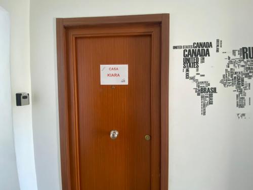 a door with a sign on it next to a world map at CASA KIARA in San Martín de la Vega