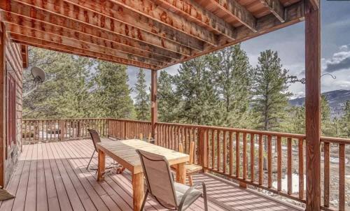 a wooden deck with a wooden table and chairs on it at Doty's River Inn is a Peaceful 3bd in Twin Lakes in Twin Lakes