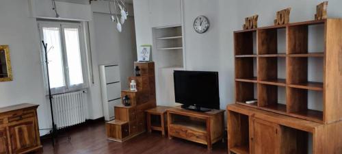 a living room with a tv and wooden shelves at Sempione Red&Silver in Milan