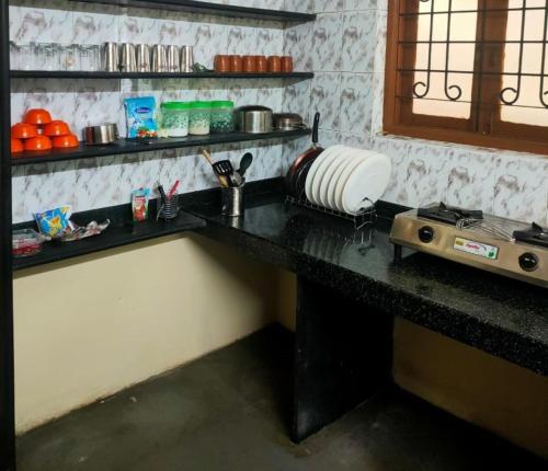a counter in a kitchen with a counter top with a stove at Patil Homestay AC in Belgaum