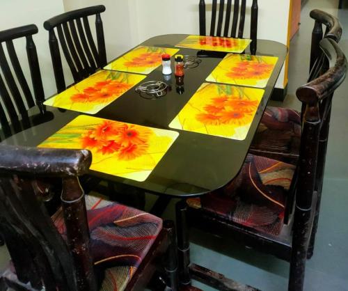 a table with a yellow and orange table cloth on it at Patil Homestay AC in Belgaum