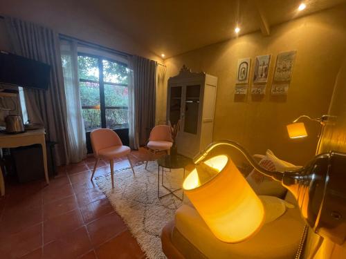 een woonkamer met een lamp en een tafel en stoelen bij Mas de Provence en Riviera in La Roquette-sur-Var