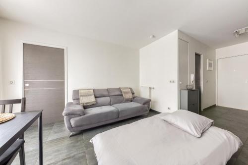 un salon avec un canapé et un lit dans l'établissement Ô COCON DE FRANCONVILLE - LOGEMENT AVEC GRANDE TERRASSE - 24H ACCESS, à Franconville