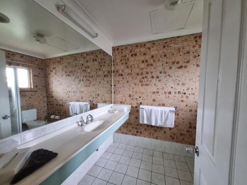 łazienka z umywalką i dużym lustrem w obiekcie Cardiff Motor Inn w mieście Newcastle