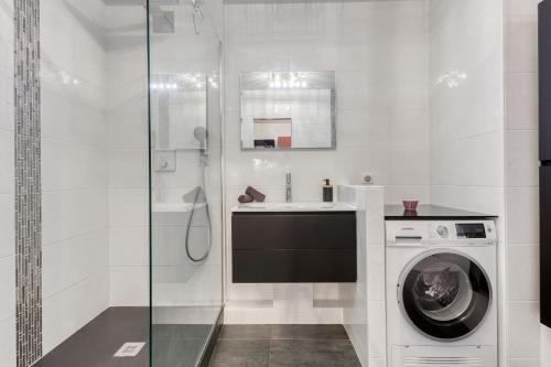 une salle de bain avec une machine à laver et un lavabo dans l'établissement Ô COCON DE FRANCONVILLE - LOGEMENT AVEC GRANDE TERRASSE - 24H ACCESS, à Franconville