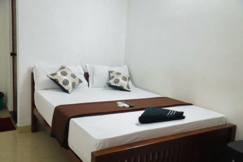 een bed met witte lakens en kussens in een kamer bij SIYA RESIDENCY in Ernakulam