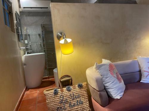 a living room with a couch and a yellow lamp at Mas de Provence en Riviera in La Roquette-sur-Var