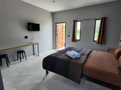 um quarto com uma cama, uma mesa e uma secretária em Check-in Resort เช็คอินรีสอร์ท em Ban Khao Khayai (1)