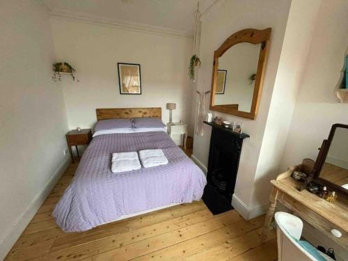 een slaapkamer met een bed met twee handdoeken erop bij Elegant, quirky home in up-and-coming Wolverton in Wolverton