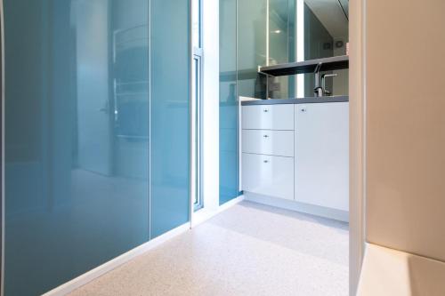 a bathroom with blue walls and a glass shower at Kina Retreat - Luxury Nelson Getaway in Tasman