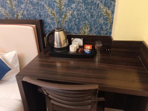 een bureau in de hotelkamer met een koffiezetapparaat bij Hotel Janki International Sigra 2 KM From Kashi Vishwanath Temple in Varanasi