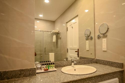 y baño con lavabo y espejo. en Devon Rest en Kandy