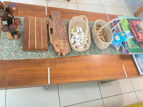 a wooden bench with baskets and other items on it at Main Stream Beach Villa in Senga