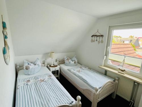 2 Einzelbetten in einem Zimmer mit Fenster in der Unterkunft Ferienwohnung Joanna in Norddeich