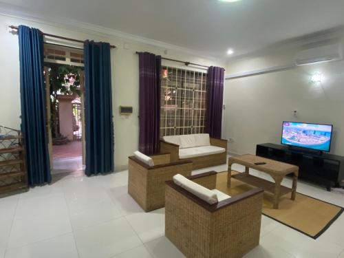 a living room with a couch and a tv at Entire Town House in Chroy Changva area in Phnom Penh