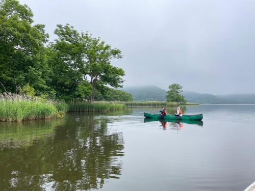 two people in a green boat on a lake at ユーカラ屋 in Nanae