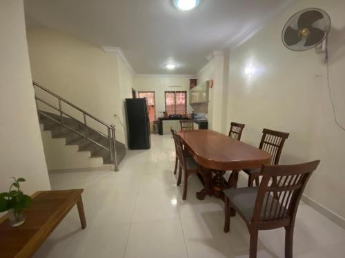 comedor con mesa de madera y sillas en Entire Town House in Chroy Changva area, en Phnom Penh