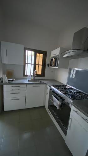 a white kitchen with a stove and a sink at Villa à Lomé in Lomé