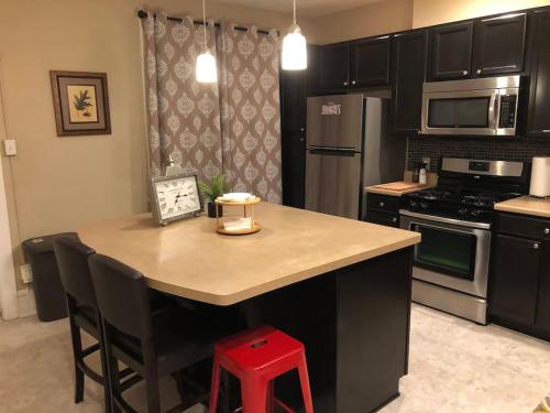 a kitchen with a kitchen island with a red stool at St Louis House near Arch and Ballpark Village in Soulard
