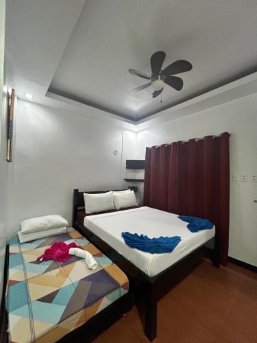 a bedroom with two beds and a ceiling fan at Seaslugs Travellers Inn in El Nido