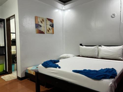 a bedroom with a bed with a blue blanket on it at Seaslugs Travellers Inn in El Nido