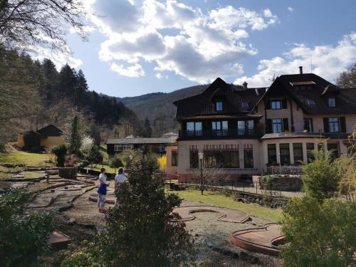 two people standing in front of a large house at Le Saint Barnabe & Spa - near Guebwiller in Buhl