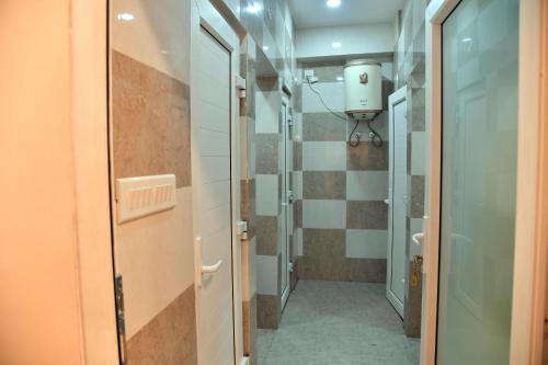 a corridor of a bathroom with a shower stall at Orange Stays in Varanasi